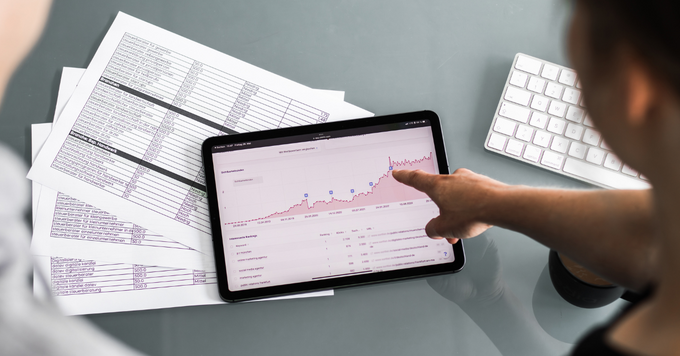Zwei Personen analysieren auf einem Tablet die Entwicklung der Sichtbarkeit einer Website anhand eines SEO- und Keyword-Dashboards mit Diagrammen und Auswertungen.