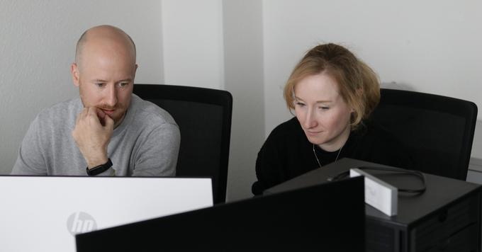 Zwei Mitarbeitende analysieren gemeinsam Inhalte und Daten am Computer, um die digitale Sichtbarkeit und Content-Strategie für Suchmaschinen und KI-Systeme zu optimieren.