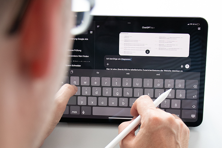 Björn sitzt an seinem Tablet. Dort ist ein Chat mit ChatGPT geöffnet.